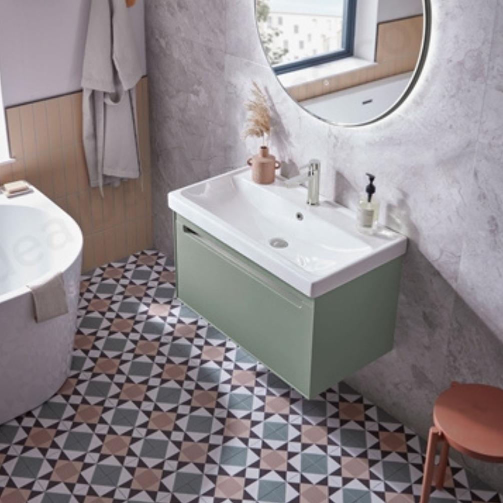 Lifestyle image of the Tavistock Acumen 800mm Laurel Green Wall-Hung Vanity Unit & Basin installed in a bathroom, below a rounded mirror